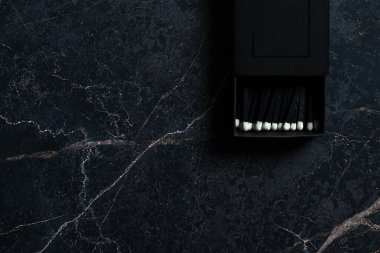 Siyah, mermer bir arka planda siyah bir kutuda beyaz bir kafayla eşleşiyor..