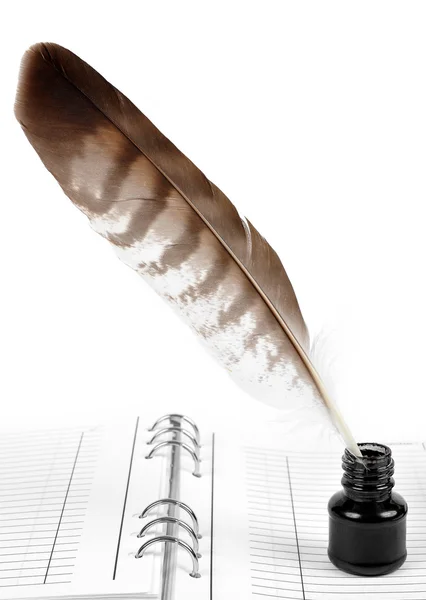 Feather with ink bottle and workbook — Stock Photo, Image