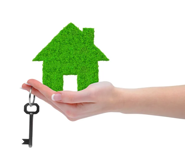 Groen huis met sleutel in hand — Stockfoto