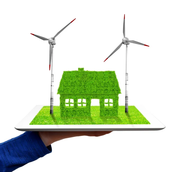 Hand holding een tablet met groene huis en wind turbines — Stockfoto