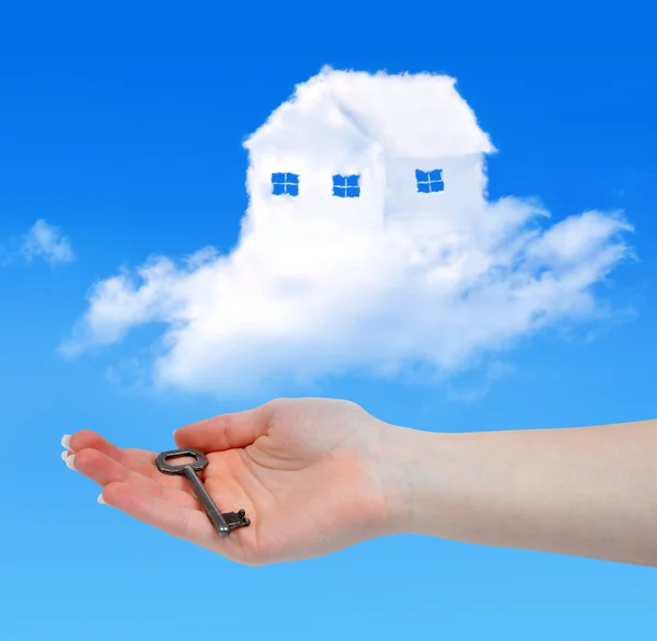 Casa de nuvens e mão com chave — Fotografia de Stock