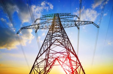Electric pylon. Transmission tower with sunset sky at the background.