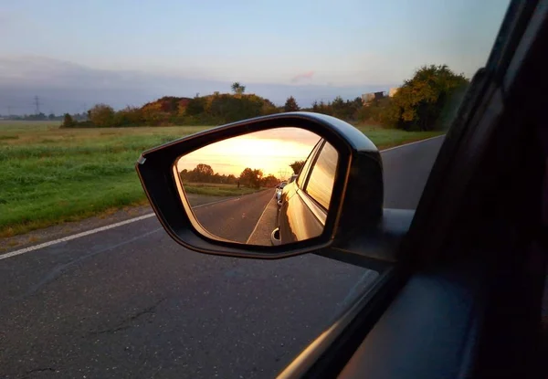 View of sunrise light in rear car mirror. Beautiful morning sunrise light reflection in rear car mirror.