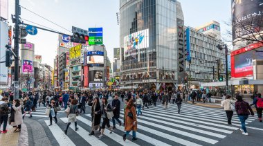 Tokyo, Japonya - 8 Ocak 2020. Birçok insan işlek caddelerde yürüyor ve gün batımında ünlü Shibuya Geçidi 'nden geçiyor. Shibuya Tokyo 'daki en ünlü kavşaklardan biridir..