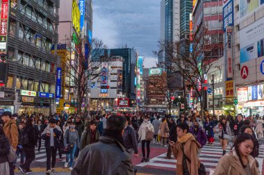 Tokyo, Japonya - 8 Ocak 2020. Birçok insan işlek caddelerde yürüyor ve gün batımında ünlü Shibuya Geçidi 'nden geçiyor. Shibuya Tokyo 'daki en ünlü kavşaklardan biridir..