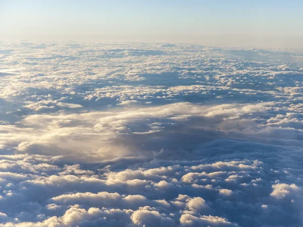 Utsikten från fönstret i ett flygplan som flyger över molnen. skyskrapor — Stockfoto