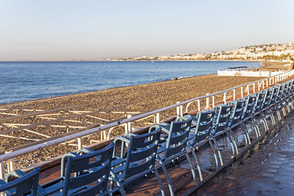 Mediterranean, French Riviera . Coastline in Nice. Chairs on the boardwalk, turned towards the sea