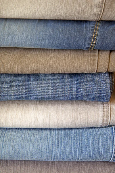 Pilha de jeans em cores diferentes — Fotografia de Stock