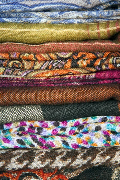 Montón de bufandas de colores en el mostrador — Foto de Stock