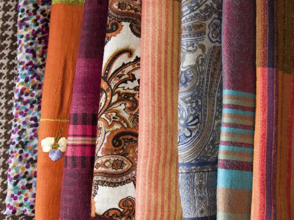 Pila di sciarpe colorate sul bancone — Foto Stock