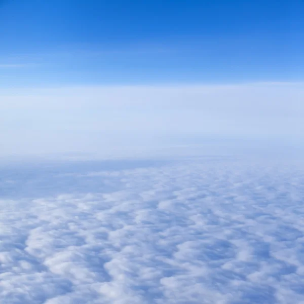 Uitzicht vanuit het raam van het vliegtuig op een dichte witte wolken — Stockfoto