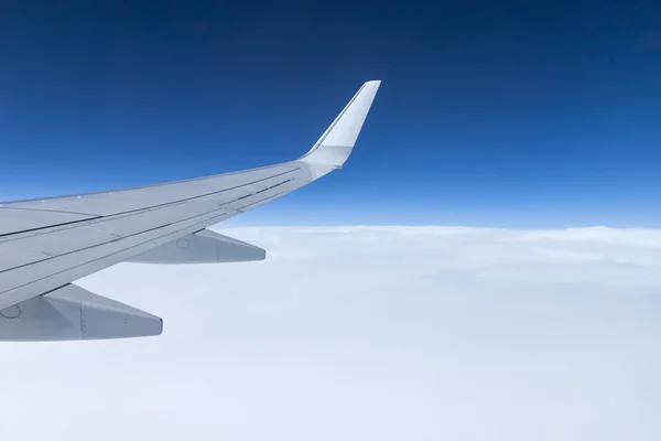 Blick auf die dichten Wolken und den Flügel eines Flugzeugfensters — Stockfoto