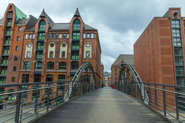 Hamburg, Almanya, 19 Şubat 2013. canal ve eski binalar Ambarlar ve bulutlu kış hava tarihi şehirde ofislerinde üzerinde köprü — Stok fotoğraf