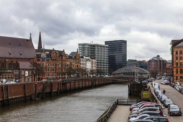 Hamburg, Německo, 19 února 2013. Most přes kanál a starých budov skladů a kanceláří v historickém městě v zatažené zimní počasí — Stock fotografie