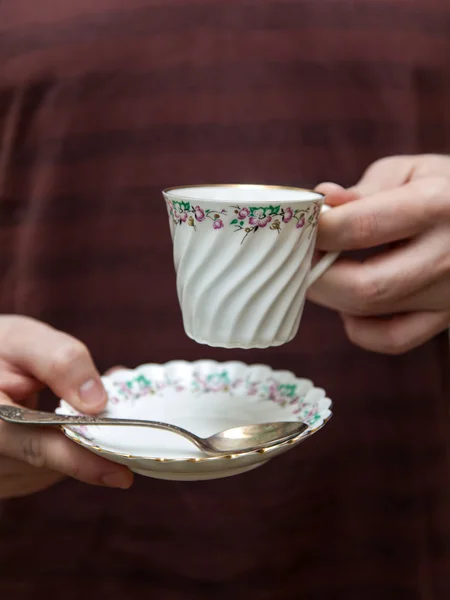 Porzellantasse mit Kaffee in der Hand eines jungen Mannes — Stockfoto