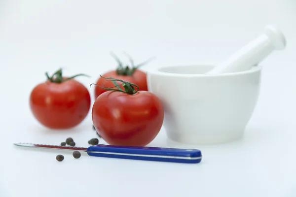 White porcelain mortar with pestle and tomatoes — Stock Photo, Image