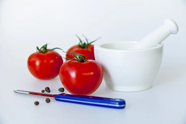 White porcelain mortar with pestle and tomatoes — Stock Photo, Image