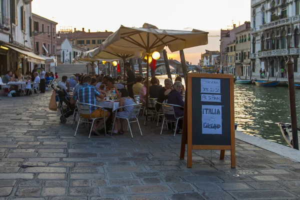 Венеция, Италия, 24 июня 2012 года. Вроде венецианского канала ранним вечером. Туристы отдыхают в кафе на берегу — стоковое фото