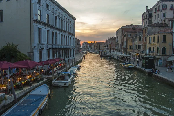 Venice, Italy, June 24, 2012 . Kind of a Venetian canal in the early evening . Tourists rest in a cafe on the shore — Stock Photo, Image