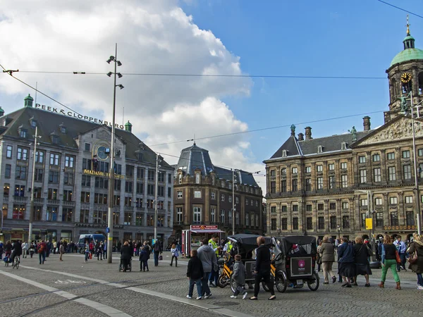 Amsterdam, die niederlande, 12. april 2012. Touristen spazieren auf dem damm platz — Stockfoto