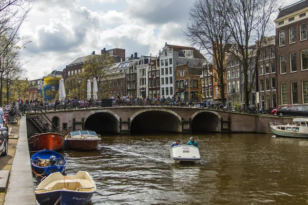 Amsterdam, Holandia, 14 kwietnia 2012. przyjemność statek płynie za pośrednictwem kanałów w centrum miasta obok starych domów o tradycyjnej architektury — Zdjęcie stockowe