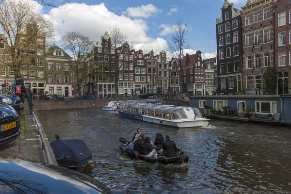 Amsterdam, Nederland, 14 april 2012. plezier schip vaart door het kanaal in het centrum van de stad langs de oude huizen van de traditionele architectuur — Stockfoto