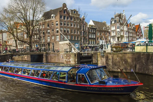 Amsterdam, Paesi Bassi, 14 aprile 2012. Nave piacere naviga attraverso il canale nel centro della città passato le vecchie case di architettura tradizionale — Foto Stock