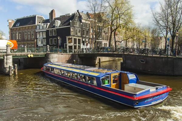 Amsterdam, Pays-Bas 16 avril 2012. Navire de plaisance navigue à travers le canal dans le centre de la ville passé les vieilles maisons de l'architecture traditionnelle — Photo