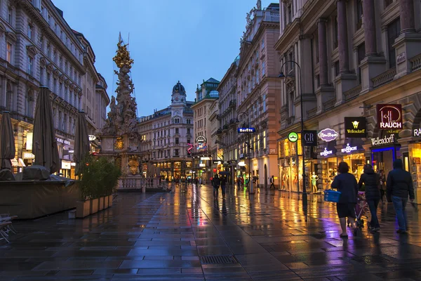 Wien, Österreich. Touristen laufen bei regnerischem Wetter auf den Abendstraßen — Stockfoto