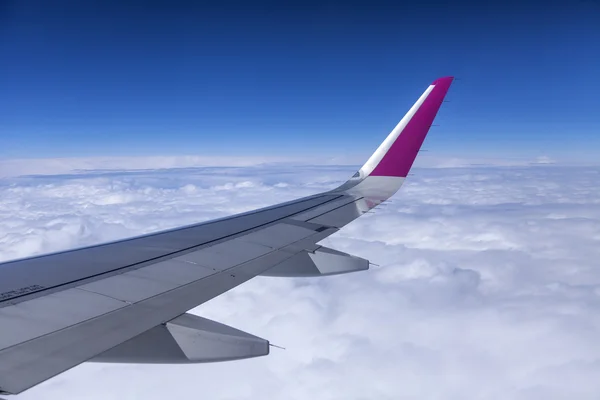 Vliegtuig uitzicht uit het raam op zijn vleugels en een dichte bed van wolken — Stockfoto