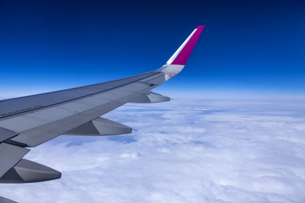 Flugzeug Blick aus dem Fenster auf seinem Flügel und ein dichtes Bett aus Wolken — Stockfoto