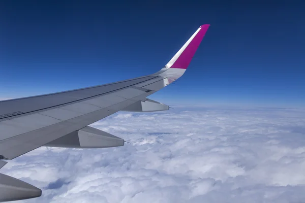 Blick aus dem Fenster des fliegenden Flugzeugs auf Erde und Wolken — Stockfoto