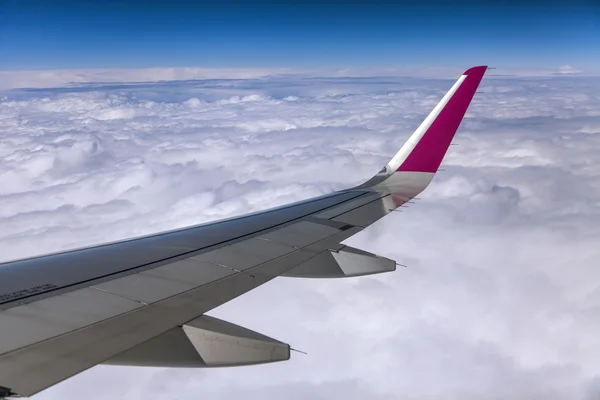 Blick aus dem Fenster des fliegenden Flugzeugs auf Erde und Wolken — Stockfoto