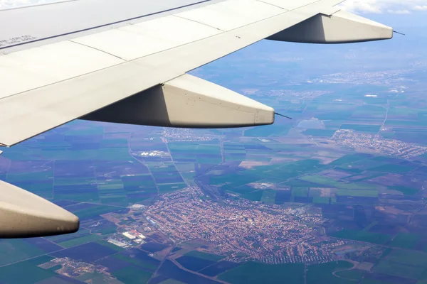 Vista dal finestrino dell'aereo volante sulla terra e le nuvole — Foto Stock