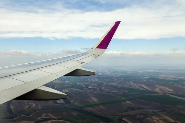 Widok z okna latający samolot na ziemi i chmury — Zdjęcie stockowe