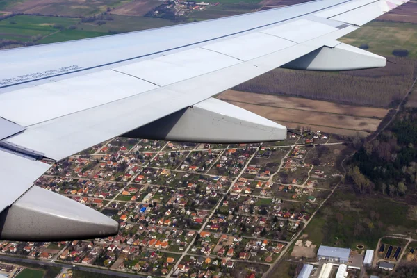 Vista desde la ventana del avión volador sobre la tierra y las nubes — Foto de Stock