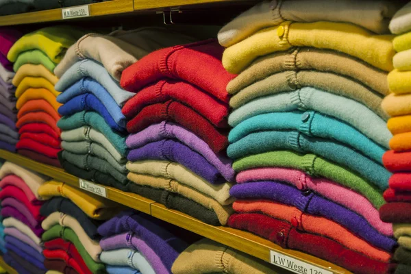 Piles of multi-colored cashmere products on shelves in the shop — Stock Photo, Image