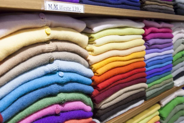 Piles of multi-colored cashmere products on shelves in the shop — Stock Photo, Image