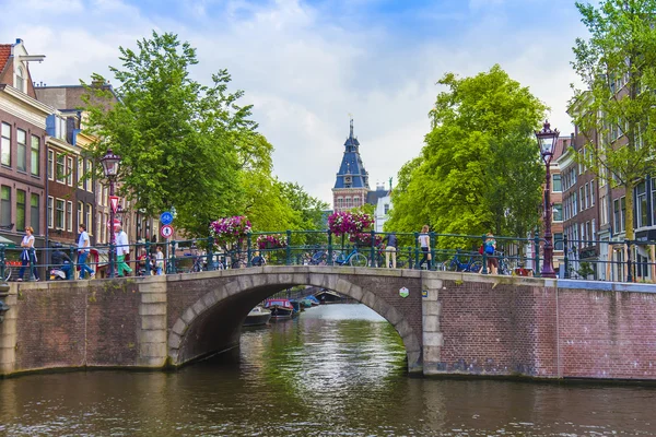 Amsterdam, Nederland, op 7 juli 2014. typisch stedelijke weergave met oude huizen aan de oever van het kanaal — Stockfoto