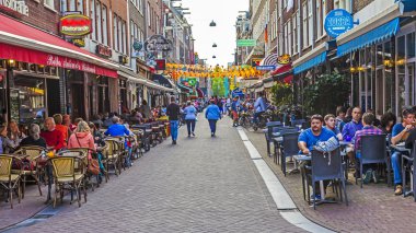 Amsterdam, Hollanda, 7 Temmuz 2014 tarihinde. turistler ve vatandaşların oturup café'de sokakta küçük tablolar