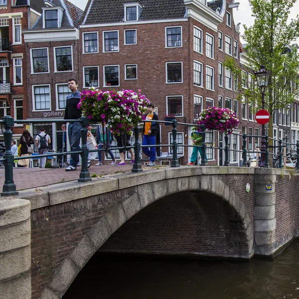 Amsterdam, Holandia, na 7 lipca 2014 roku. typowy widok ze starych domów na brzegu kanału i kamienny most — Zdjęcie stockowe