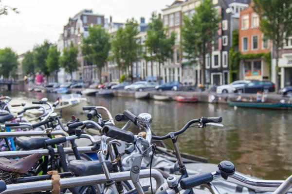 Ámsterdam, Países Bajos, 7 de julio de 2014. Bicicletas en la orilla del canal. La bicicleta es un tipo de transporte muy popular en Holanda — Foto de Stock