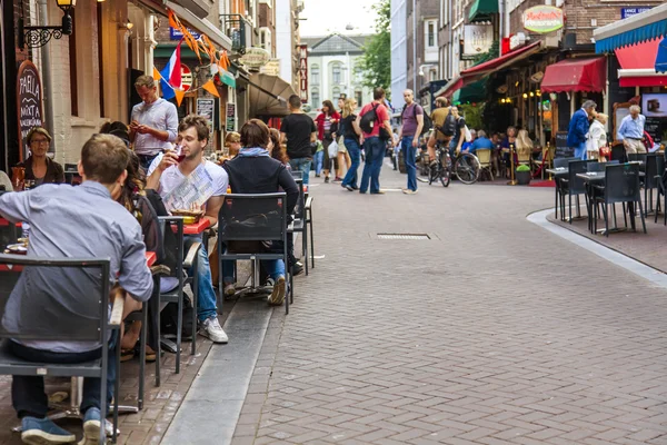 Amsterdam, Nizozemsko, na 7 červenci 2014. turisté a občané sedět v kavárně málo stolů na ulici — Stock fotografie