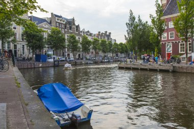 Amsterdam, Hollanda, 7 Temmuz 2014 tarihinde. Banka kanalı ve eski taş köprü evleriyle tipik kentsel görünümü