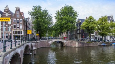 Amsterdam, Hollanda, 7 Temmuz 2014 tarihinde. Banka kanalı ve eski taş köprü evleriyle tipik kentsel görünümü