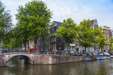 Amsterdam, Hollanda, 7 Temmuz 2014 tarihinde. Banka kanalı ve eski taş köprü evleriyle tipik kentsel görünümü