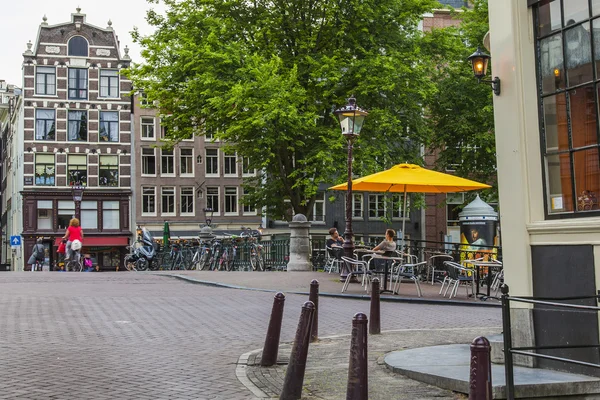 Amsterdam, Pays-Bas, le 7 juillet 2014. Touristes et citoyens s'assoient à des petites tables de café dans la rue — Photo