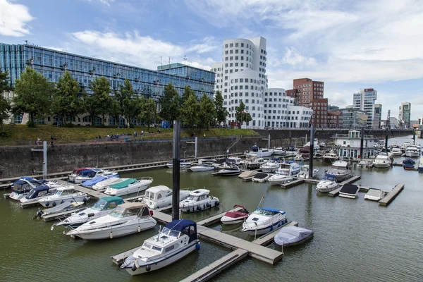 Düsseldorf, Tyskland, på 6 juli 2014. arkitektoniskt komplex av rhine vallen i området media hamnen och båtarna på förtöjningen — Stockfoto