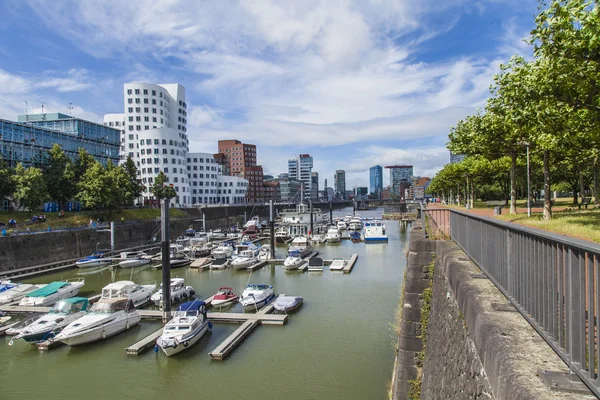 Düsseldorf, Tyskland, på 6 juli 2014. arkitektoniskt komplex av rhine vallen i området media hamnen och båtarna på förtöjningen — Stockfoto