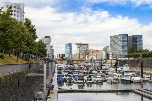 Düsseldorf, Tyskland, på 6 juli 2014. arkitektoniskt komplex av rhine vallen i området media hamnen och båtarna på förtöjningen — Stockfoto